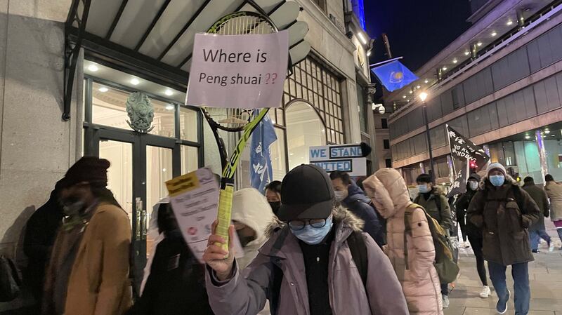 有游行人士举起网球拍,展示写上“彭帅在哪里?”(Where is Peng Shuai?)字句的标语,表达对中共噤声的不满。(吕熙摄)