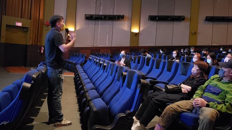 电影导演欧文杰(站立者)与观众分享观感,香港电影人崔允成则通过越洋电话与观众交流。 (记者柳飞拍摄)