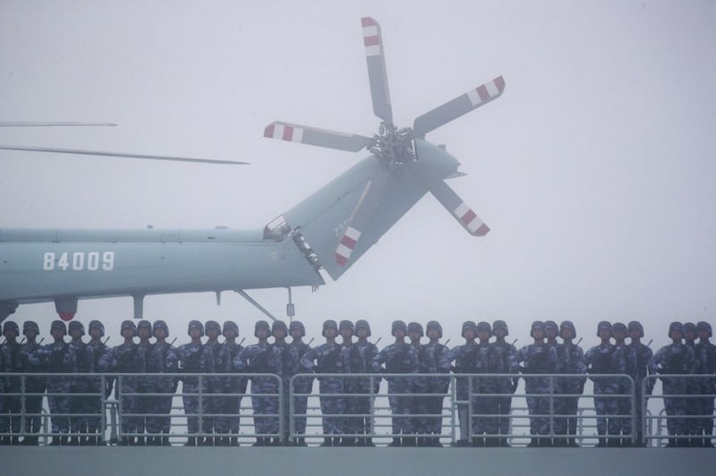Soldiers stand on deck of the ambitious transport dock Yimen Shan of the Chinese People's Liberation Army (PLA) Navy as it participates in a naval parade to commemorate the 70th anniversary of the founding of China's PLA Navy in the sea near Qingdao in eastern China's Shandong province, April 23, 2019. Credit: AFP