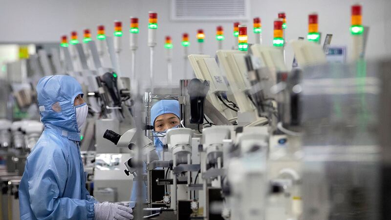 2020年5月14日,佩戴保护设备的员工在北京记者的政府组织游览期间在瑞萨电子的半导体生产设施中工作。(美联社)