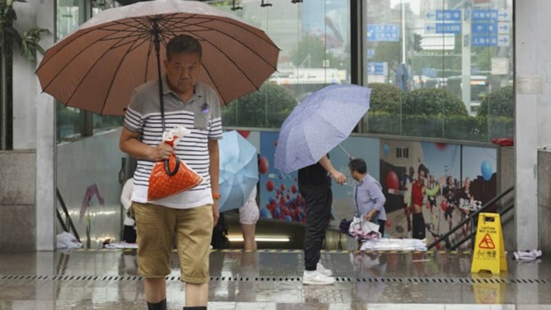 中国南方连续降雨,图为上海居民在雨中出行。(美联社)