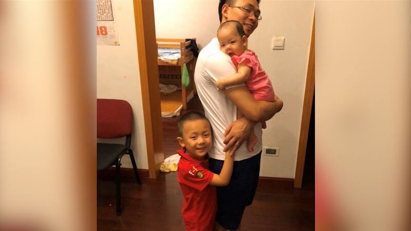 覃德富和两个孩子合影。(志愿者提供/记者乔龙)