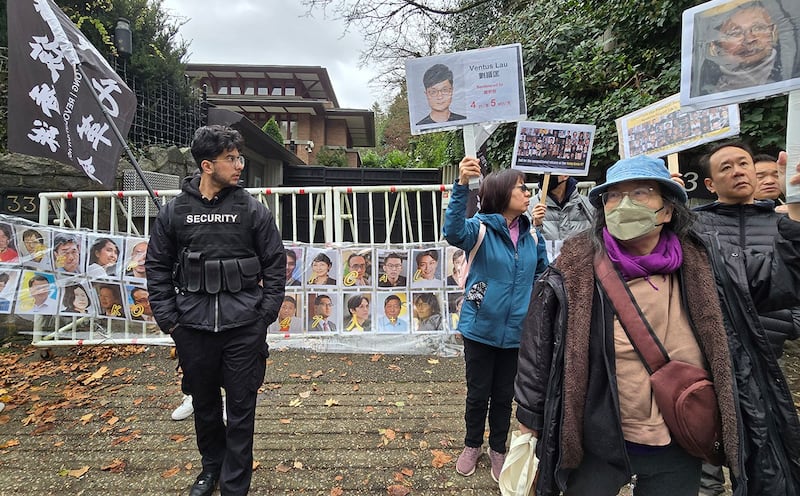 民众在中国驻温哥华领事馆前拉起了四十七人头像的横幅，为他们的无罪发出呐喊。中国领事馆特派出保全维安，保全人员并一直在现场拍照搜证。 (记者柳飞拍摄)