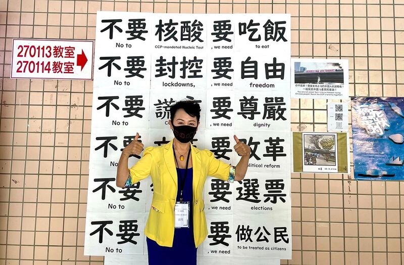 作家盛雪随台湾九合一观选团在台湾政治大学校园的四通桥标语前。(盛雪提供)