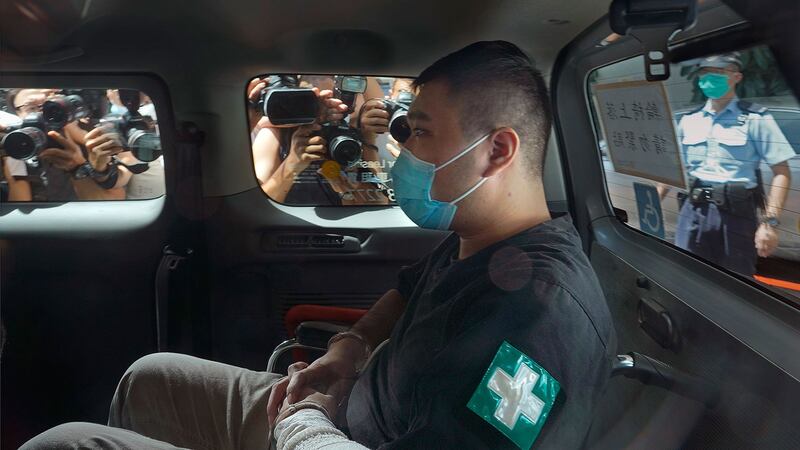 2020年7月6日,香港首位被控涉嫌违反国安法的男子唐英杰坐着轮椅由警车押解至法庭。(美联社)