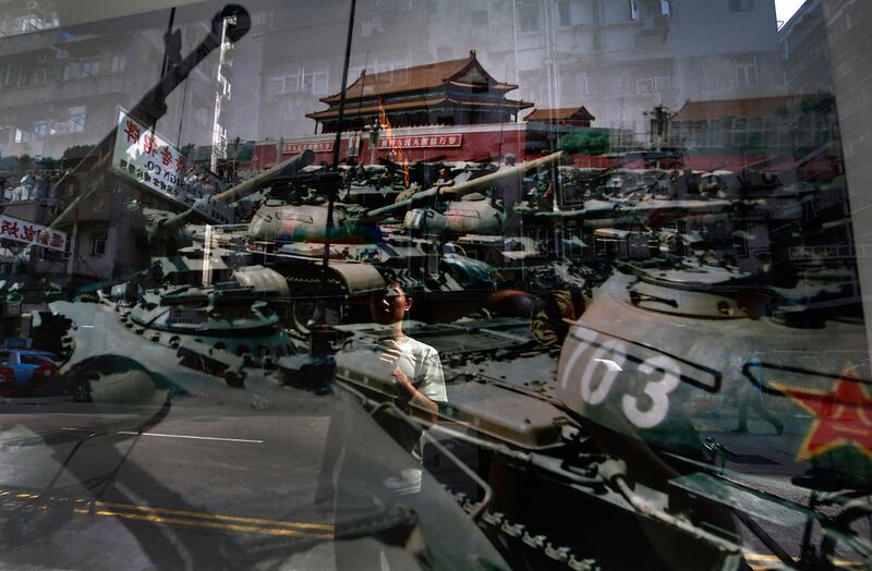 资料图片:一名男子看着一张照片,1989 年 6 月 4 日在北京天安门广场拍摄的。 (美联社)