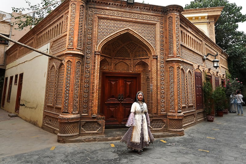 A Uyghur woman wears traditional clothing attire at the Old Kashgar tourist area in China's northwestern Xinjiang region, July 20, 2023.