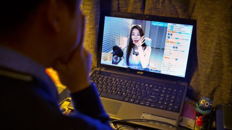 一名北京市民正在收看网络直播视频(美联社)