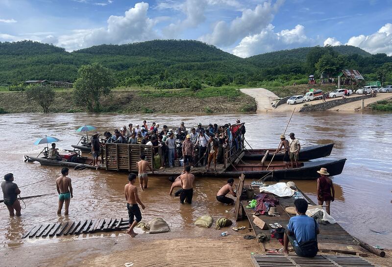 Displaced people from Lashio cross the Dokhtawaddy river as they flee their homes following clashes between Myanmar's military and the Ta'ang National Liberation Army (TNLA), in Zin Ann village between Lashio and Hsipaw township in Myanmar's northern Shan state, July 8, 2024