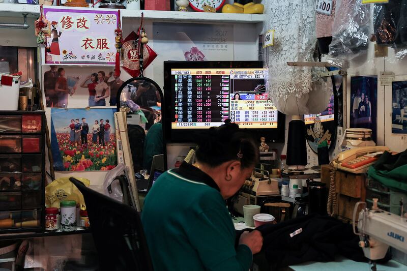 A person sits near a TV showing a live broadcast of the US election on the morning news at a store in Taipei, Taiwan November 6, 2024. REUTERS/Ann Wang