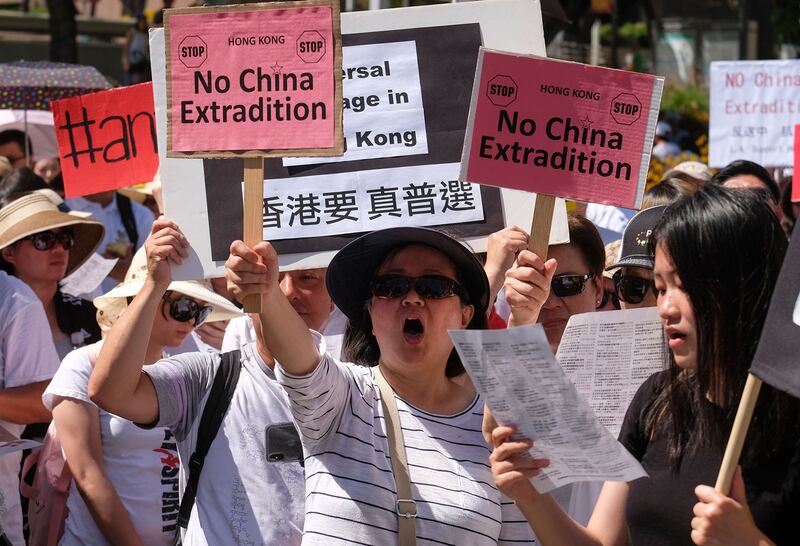 2019年6月9日,香港百万人游行反对特区政府修订《逃犯条例》,示威群众手持着“不要引渡”和“香港要真普选等”口号。(法新社)