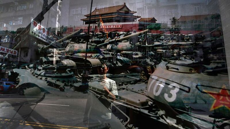 一名男子正在观看1989年6月4日摄于北京天安门广场的一张照片 （美联社资料图）