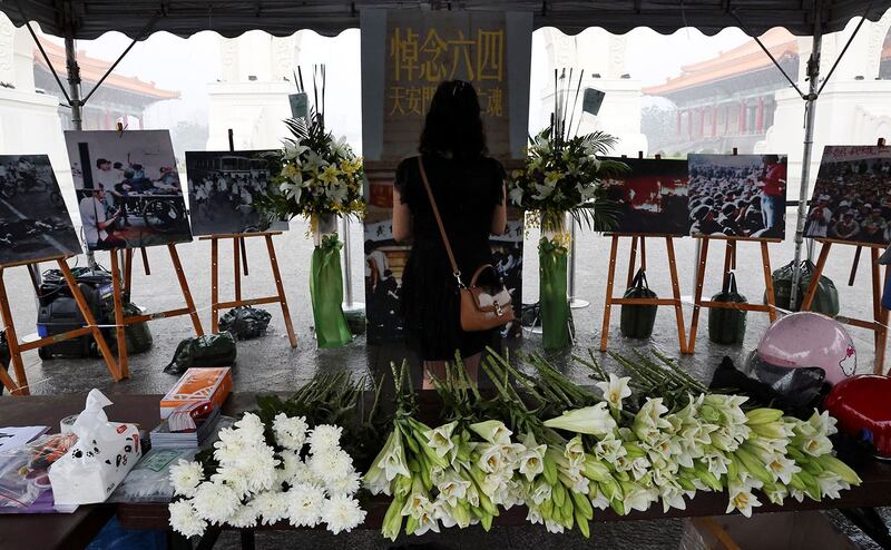 2021 年 6 月 4 日,台湾台北自由广场,一名妇女在纪念六四 32 周年的临时纪念碑上表达敬意。(路透社)