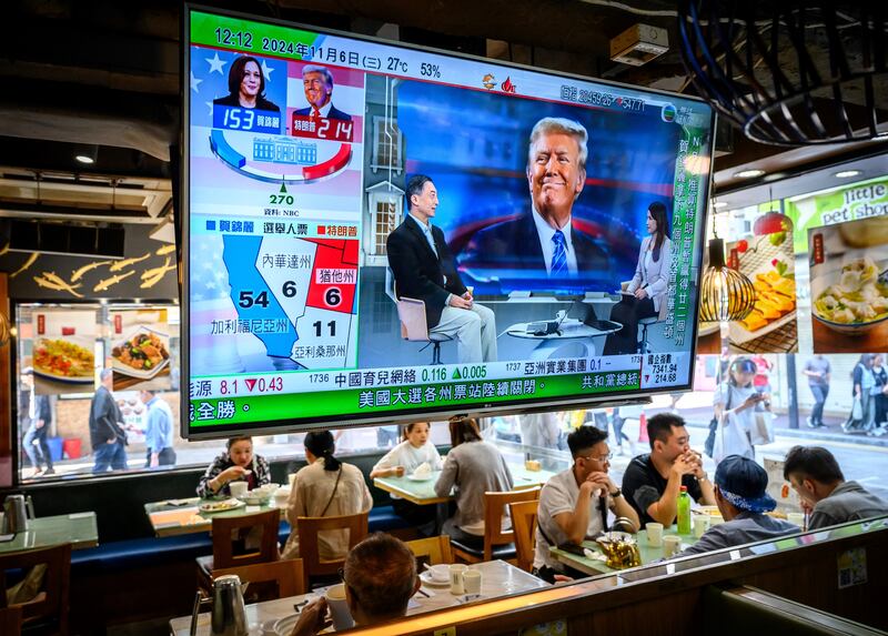 A TV screen showing preliminary results about the US elections hangs in a restaurant in Hong Kong on November 6, 2024.