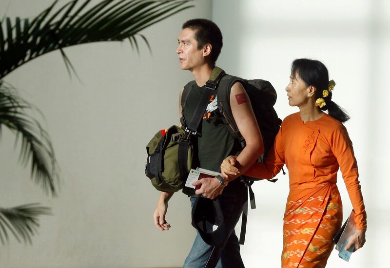 ဒေါ်အောင်ဆန်းစုကြည်နှင့် သားဖြစ်သူ ကင်မ်အဲရစ်(ခေါ်) ကိုထိန်လင်းတို့အား ၂ဝ၁ဝ ပြည့်နှစ် ဒီဇင်ဘာလ ၇ ရက်နေ့က ရန်ကုန်လေဆိပ်တွင် မြင်တွေ့ရစဉ်။ (Photo: Reuters)