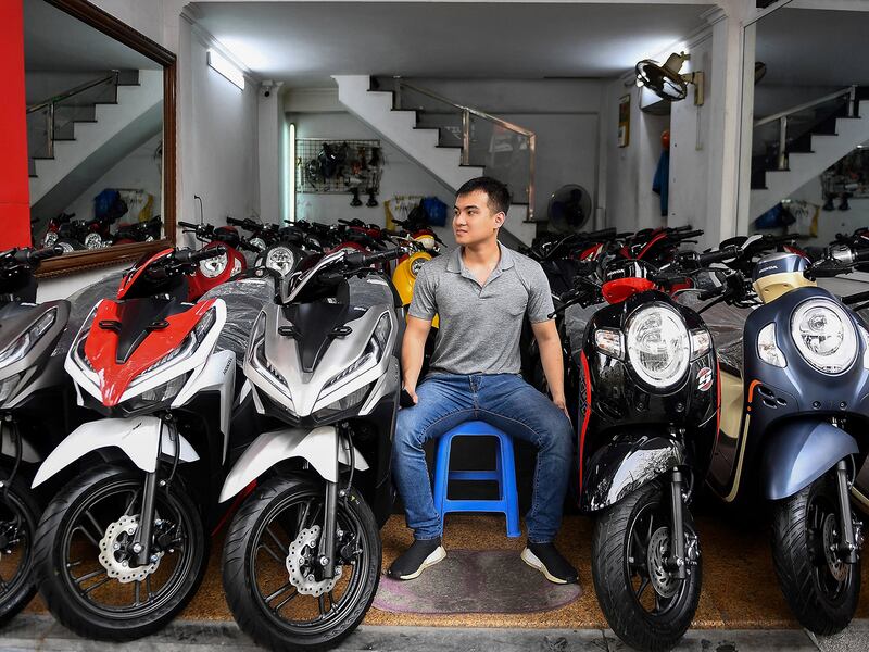A salesman waits for customers at a motorcycle and scooter showroom in Hanoi, VIetnam, March 29, 2021.