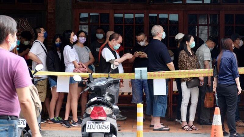 台北市万华区一处筛检站涌现人潮,排队民众并未保持适当社交距离。(法新社)