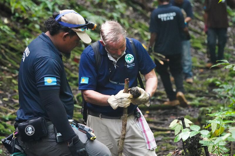 Roger Hess, right, and a member of the Norwegian People’s Aid clearance team inspect an abandoned WWII munition on Umurbrogal Mountain in Peleliu, Palau, Nov. 26, 2024.