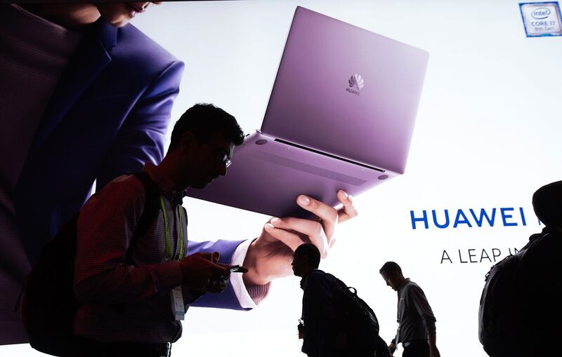 2019年1月8日,人们走过在美国拉斯维加斯举行2019国际消费电子展的华为展览区。(AFP)