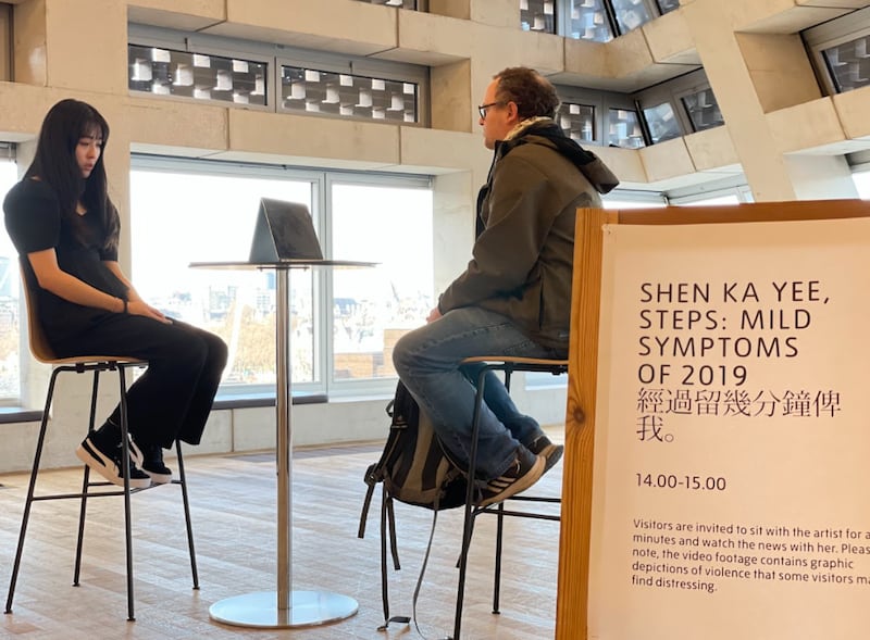 香港艺术家沈嘉仪(Shen Ka Yee)竖起了一个牌子,把这次行为艺术命名为“经过留几分钟俾我” (Steps: Mild Symptoms of 2019)。(记者吕熙摄影)