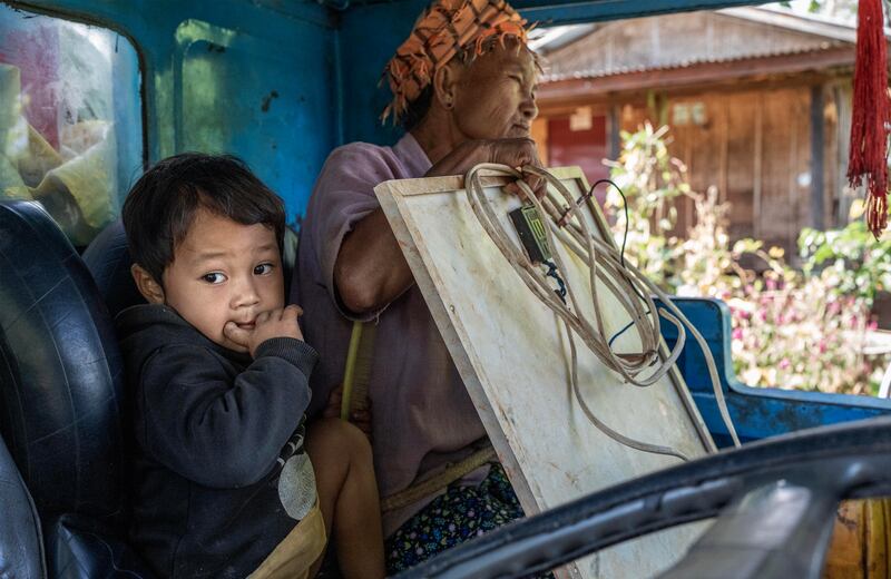 A child and her grandmother sit in a tractor to flee from Phuk Khe village as Myanmar junta attacks Moe Bye to Peinnegon main road in Shan state, Myanmar, Oct. 30, 2024.